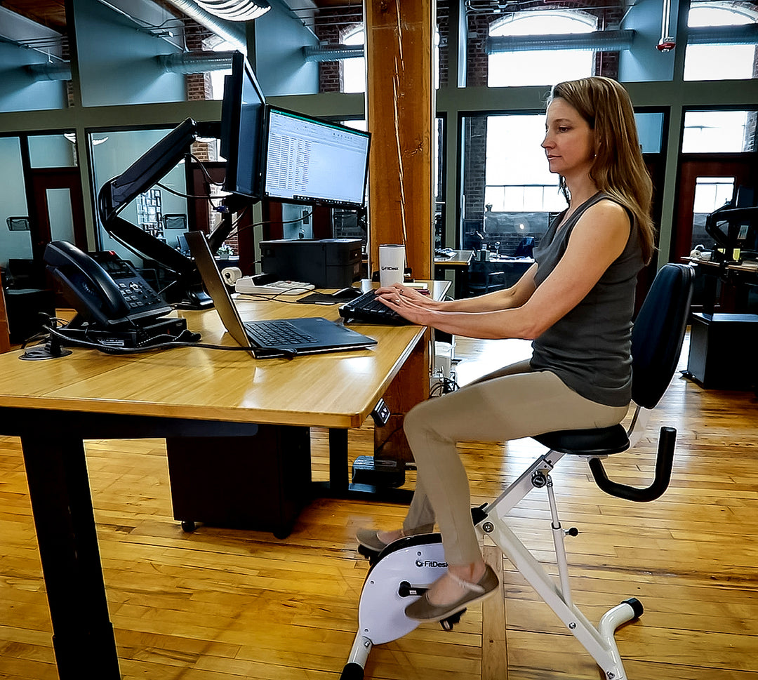 Woman Riding FitDesk Standing Desk Bike in office